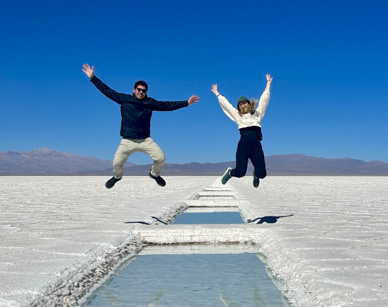 Tailored Argentina travel experts Fernanda and Pablo jumping on the Salinas Grandes salt flats.